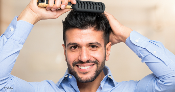 man smiling and brushing his hair
