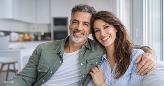 happy middle-aged couple sitting on couch in their residence