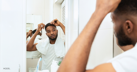 man combing hair in mirror